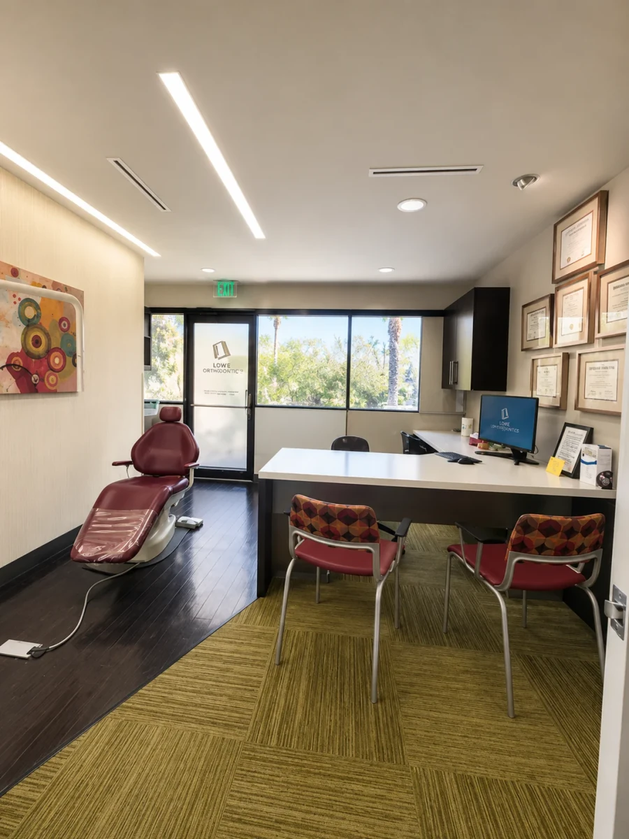 Consultation room with a dental chair, desk, computer, and visitor chairs
