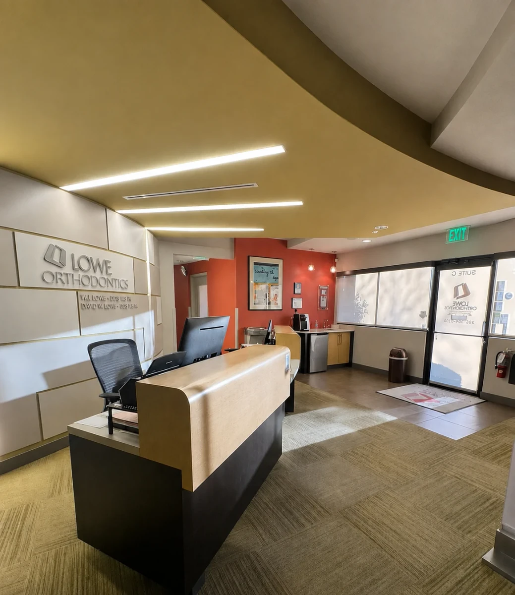 Lowe Orthodontics reception desk with the practice logo and entrance doors